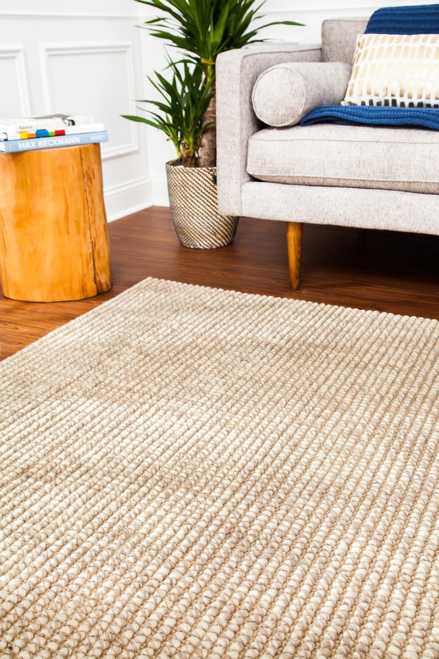 jute and wool rug corner in front of gray couch and wooden table