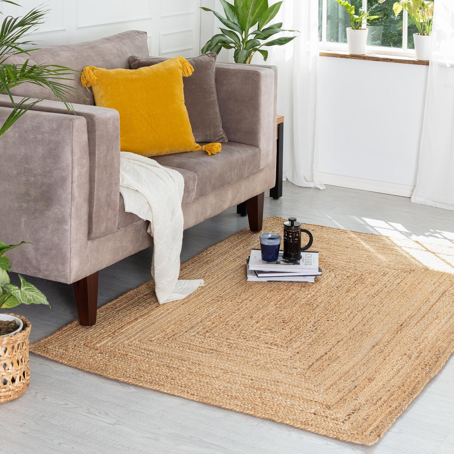 Kerala Natural Jute Rug in front of velvet couch