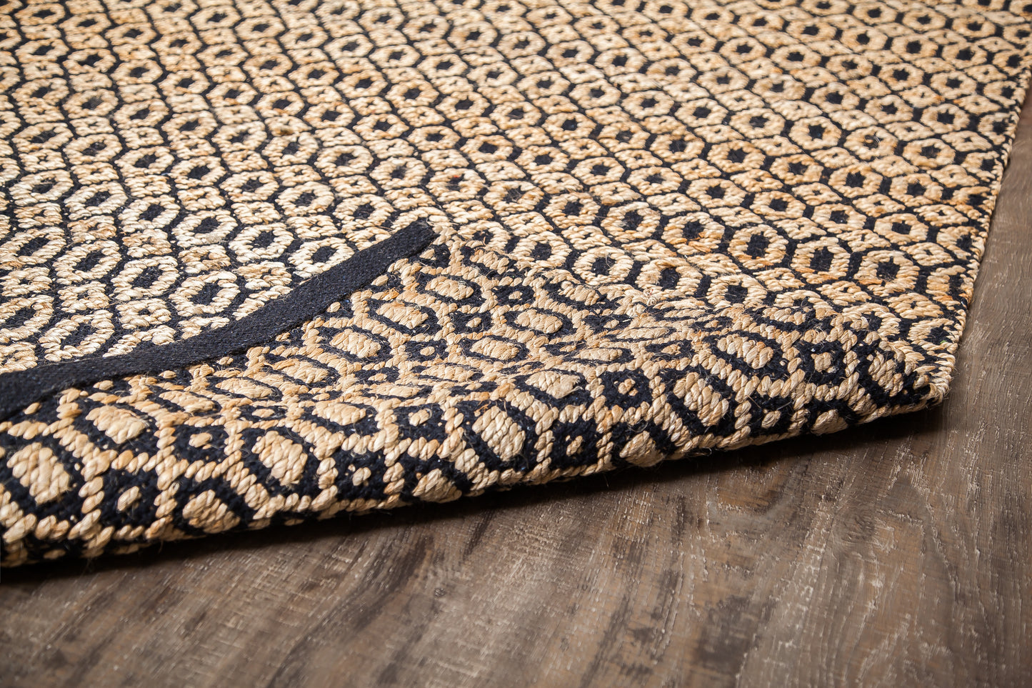 black and beige woven jute rug with corner rolled back