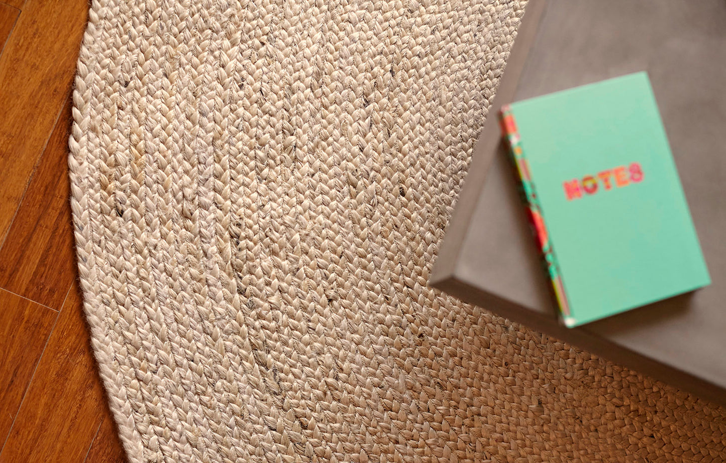 round cream jute rug beneath cofee table with journal