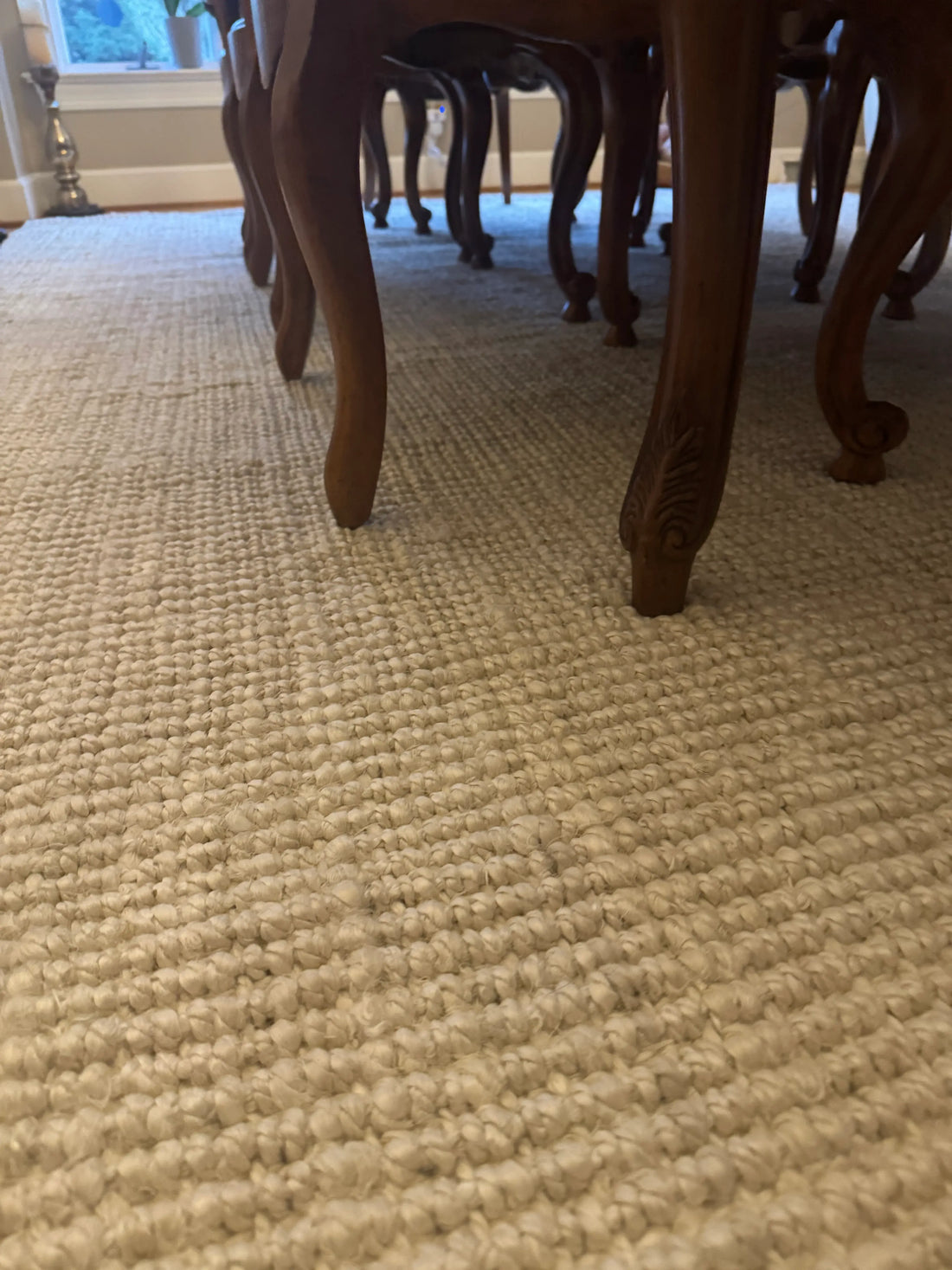 closeup of natural ivory jute rug under dining set