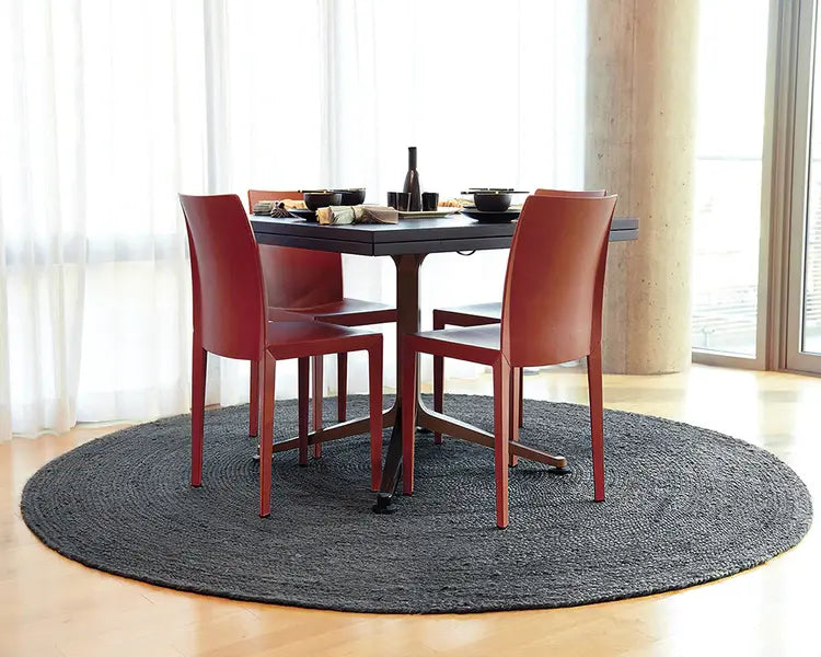 dining set with red highback chairs, round table and round gray jute rug