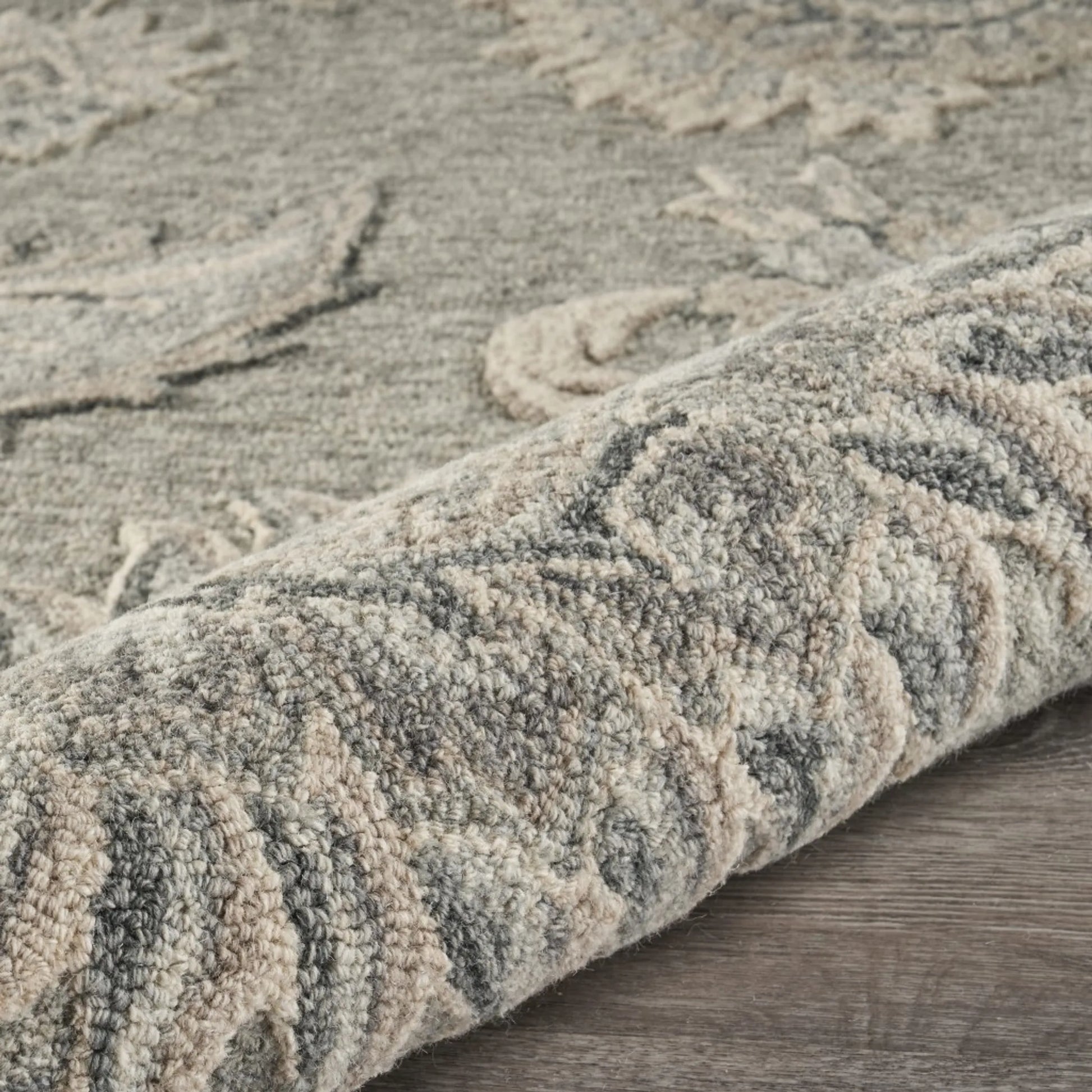 Textured wool rug with intricate patterns on a wooden floor