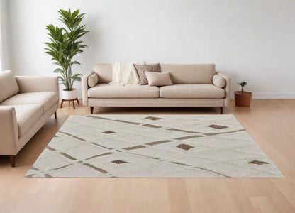 Living room with beige sofa, patterned rug, and decorative plants.