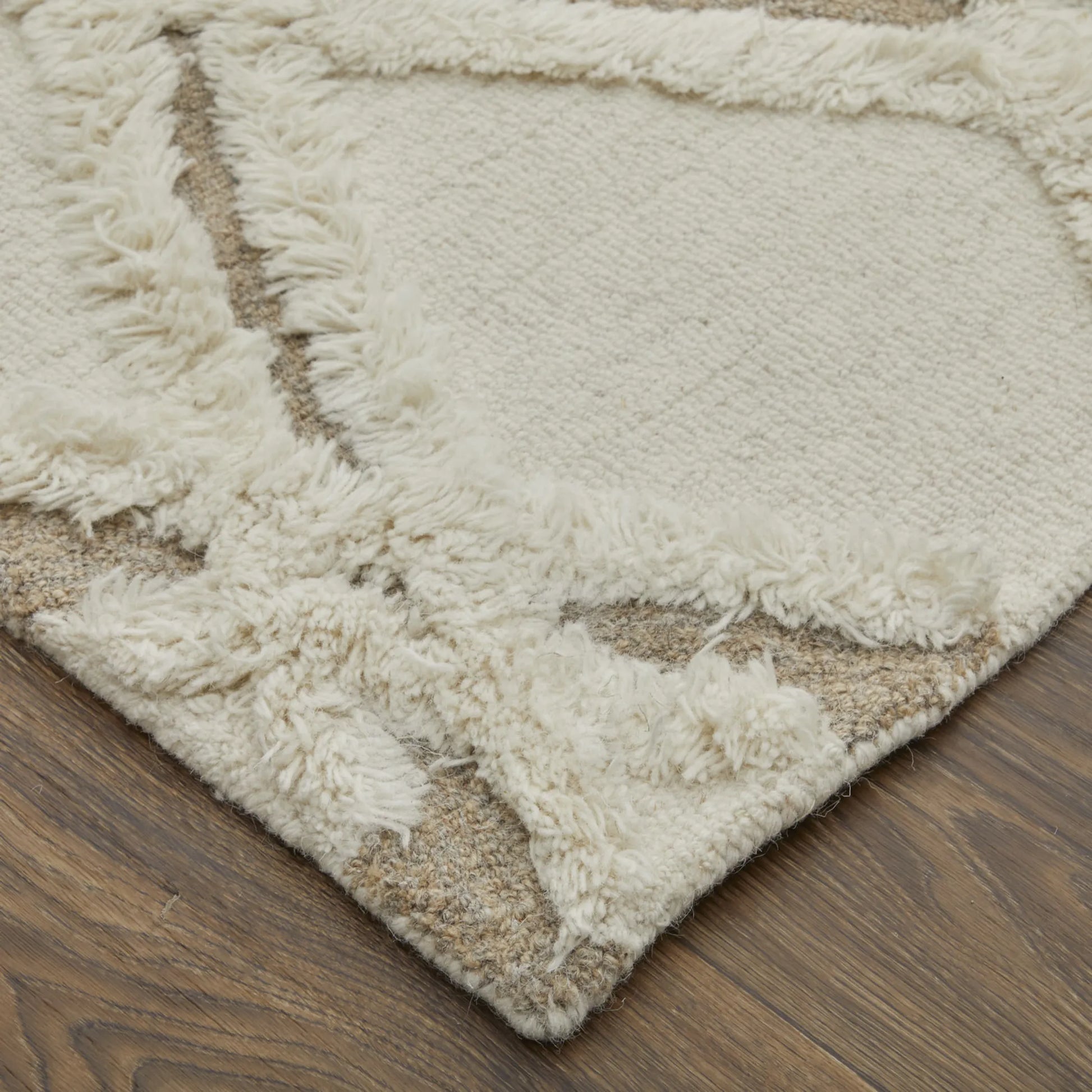 Close-up of a textured beige rug on a wooden floor