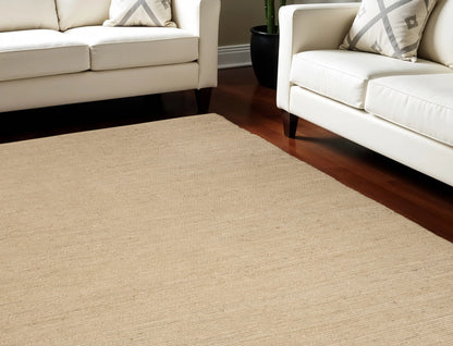 Beige jute rug in a living room with white sofas.