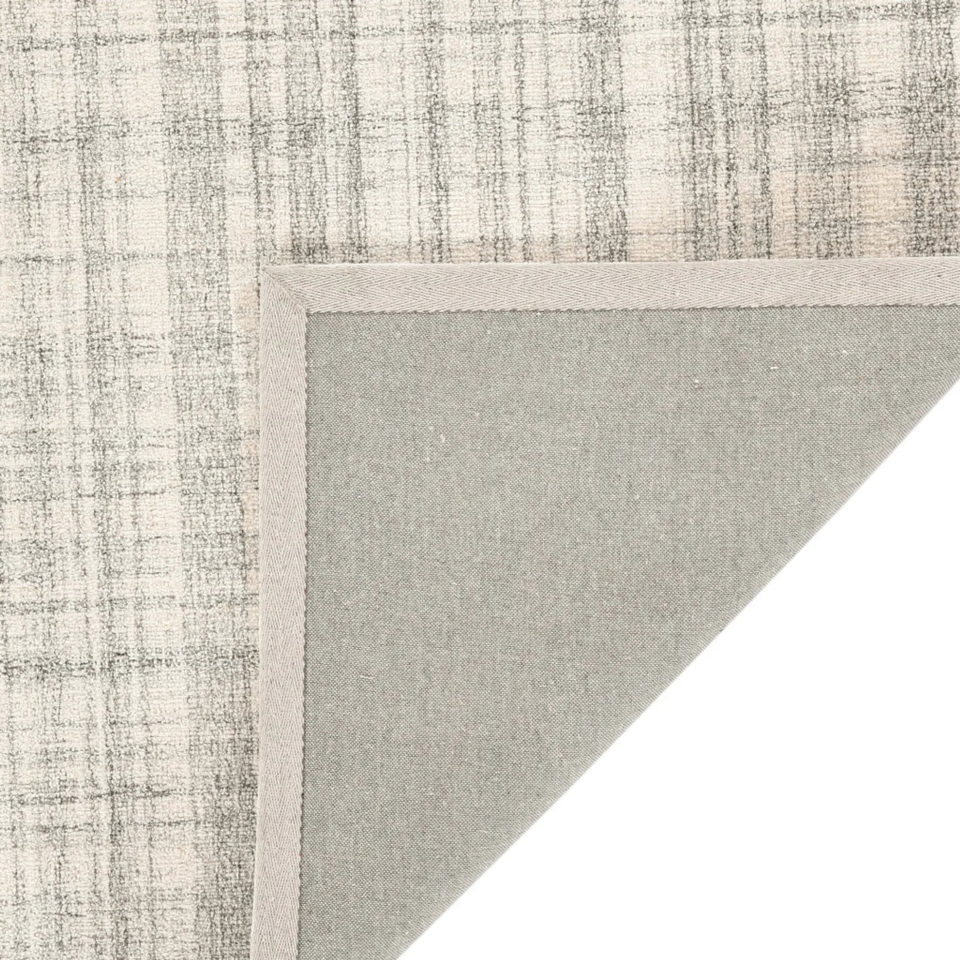 Textured wool  rug corner with a neutral color palette on a white background