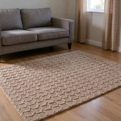 Living room with a gray sofa and a textured beige jute rug on wooden flooring.