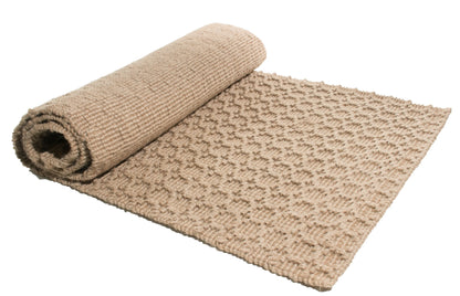 Beige textured jute rug rolled out on a white background
