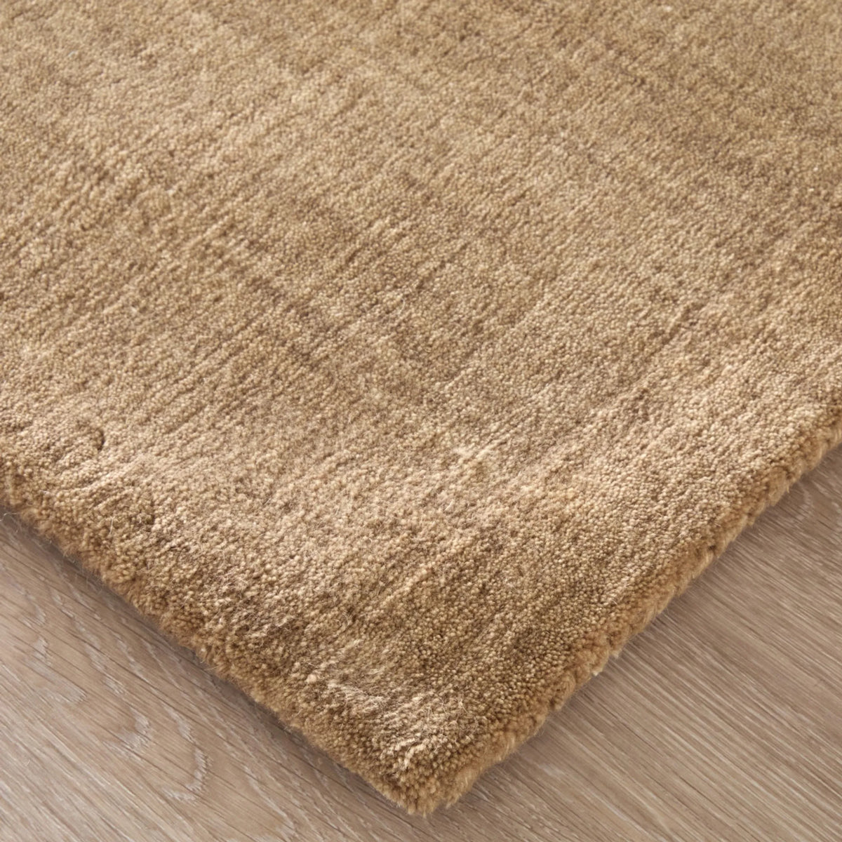 Close-up of a beige shaggy rug on a wooden floor