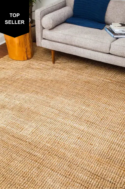 jute rug in a living room with a gray sofa and blue pillow.