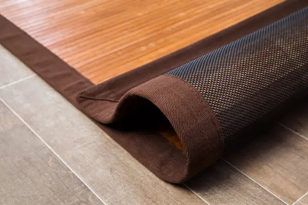 rolled back bamboo rug revealing woven backing