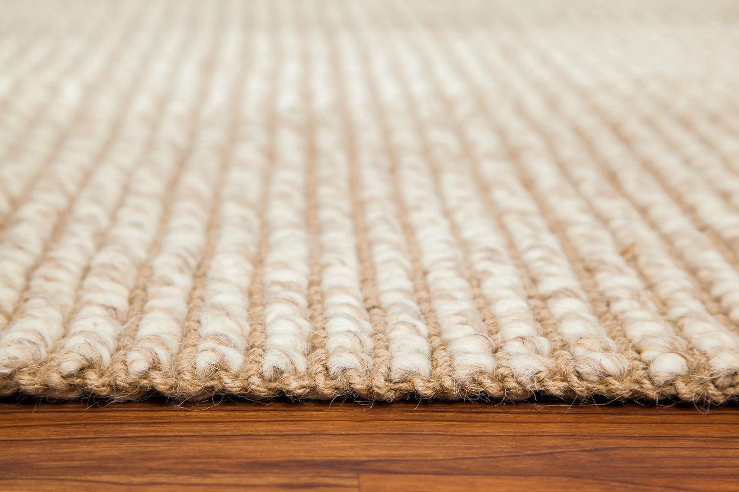 corner edge of ivory and tan woven rug
