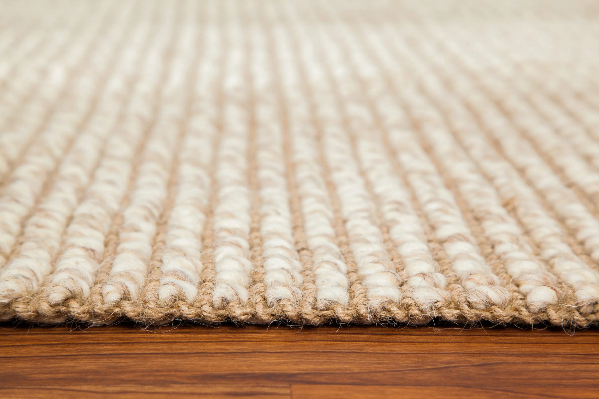 corner edge of ivory and tan woven rug