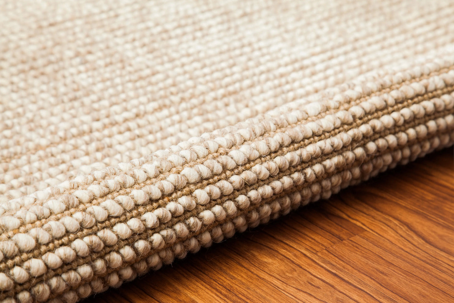 rolled up edge of textured woven rug
