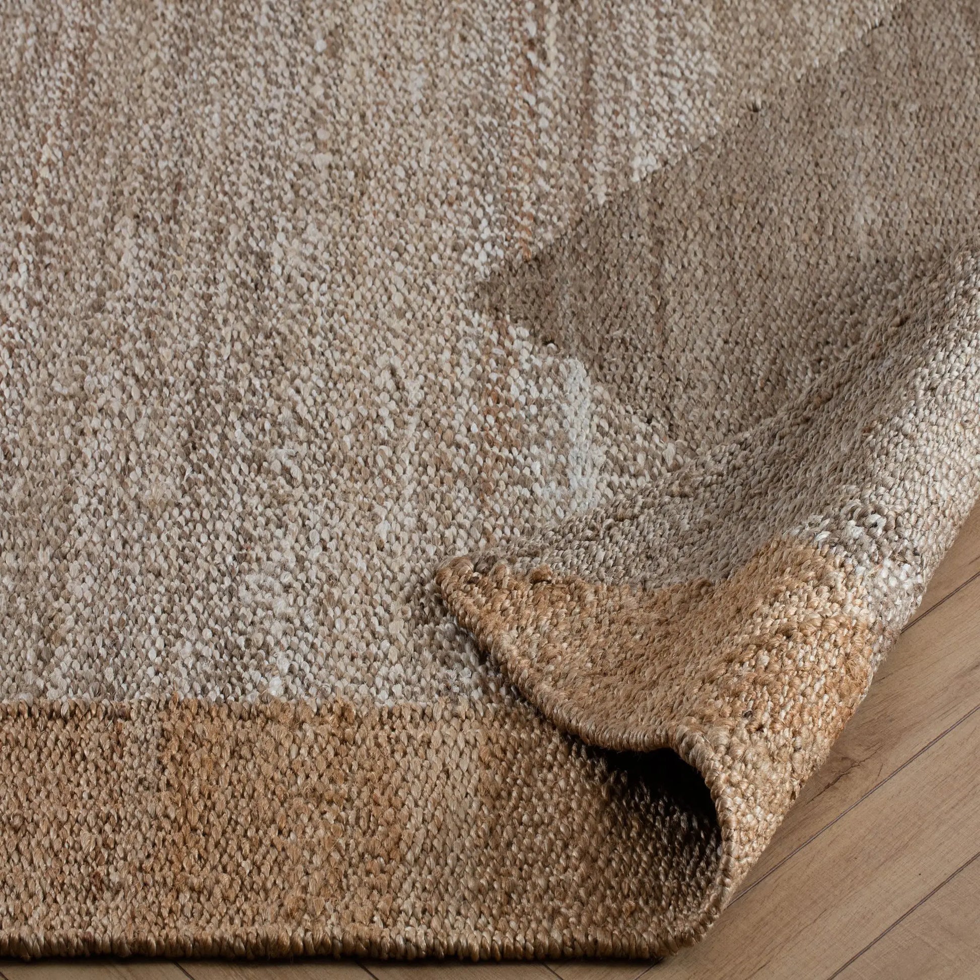 tan and taupe woven rug with corner turned back
