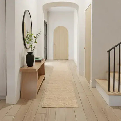 Modern hallway with wooden floor, mirror, and natural jute runner