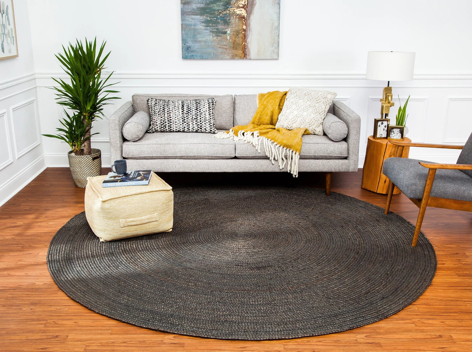 living room room with gray couch, round gray jute rug and boho decor
