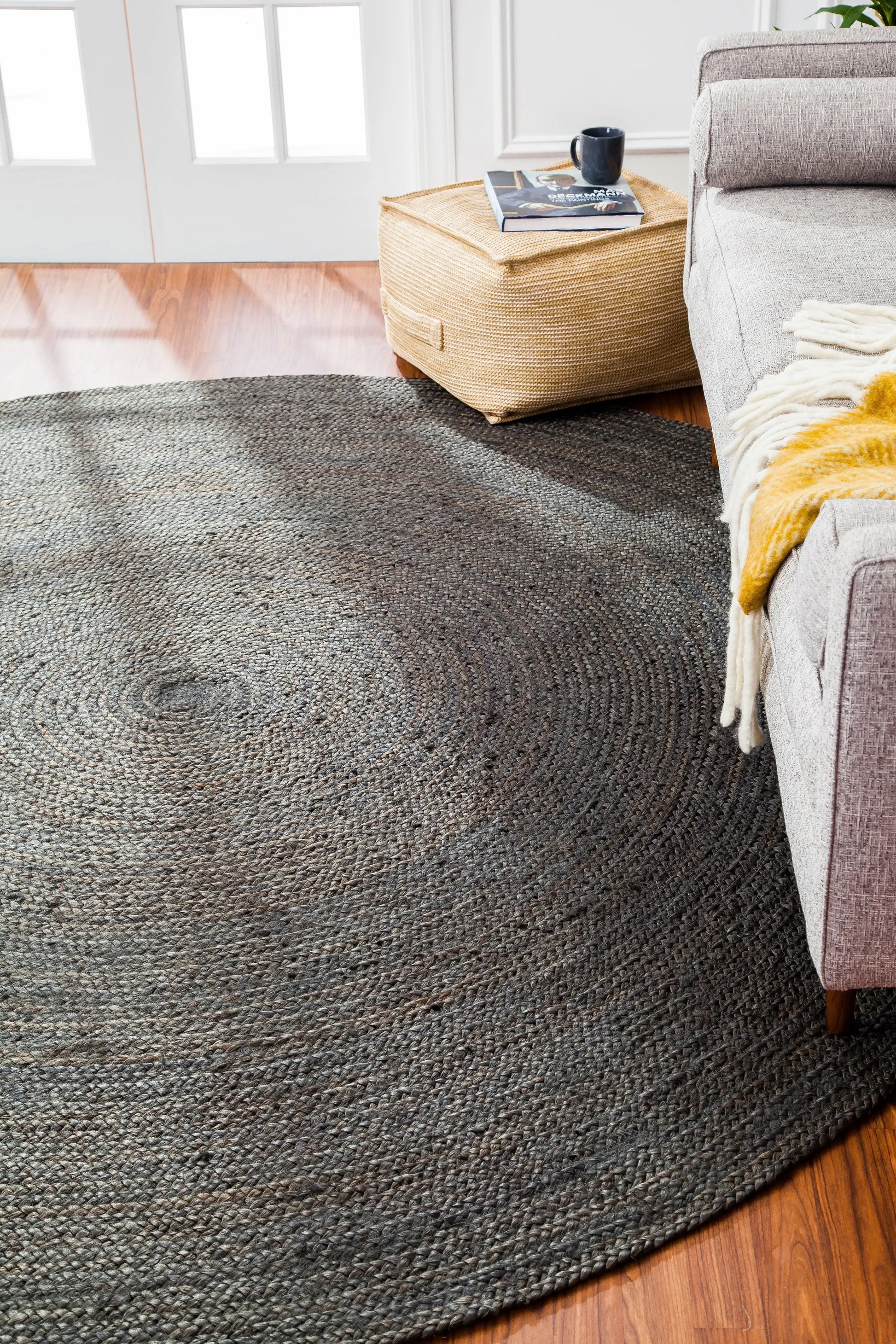 round gray jute rug in front of light gray couch