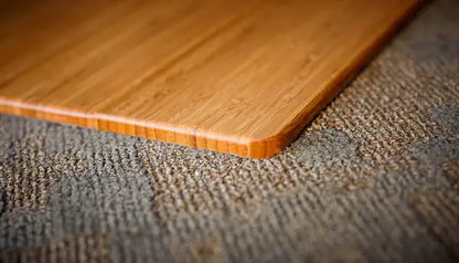curved edge of a natural bamboo chair mat on a rug
