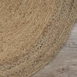 Close-up of a textured beige carpet corner on a wooden floor