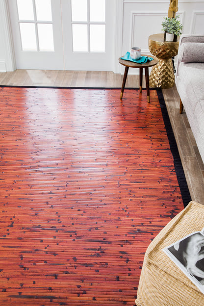 Mahogany Brick Moso Bamboo Rug overhead view in front of couch