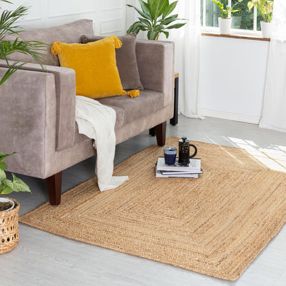 Kerala Natural Jute Rug in front of velvet couch